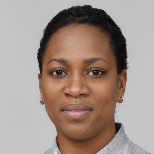 Joyful black young-adult female with short  black hair and brown eyes
