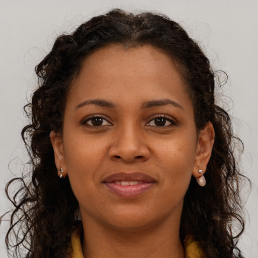 Joyful black young-adult female with long  brown hair and brown eyes