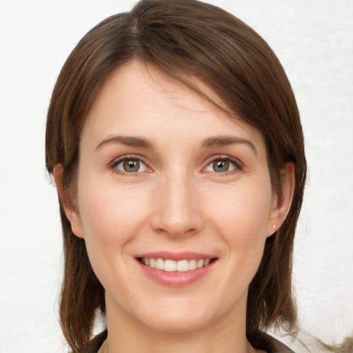 Joyful white young-adult female with medium  brown hair and grey eyes