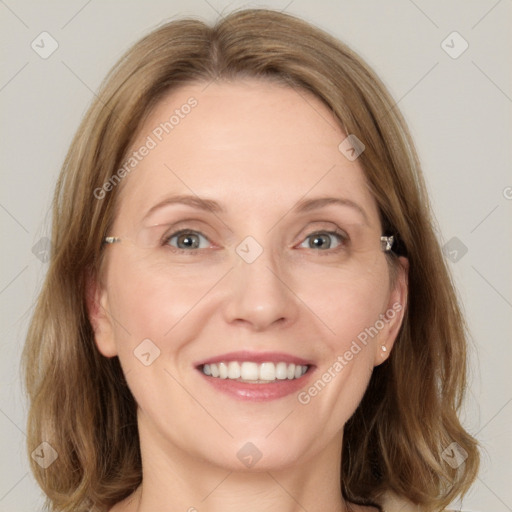 Joyful white adult female with medium  brown hair and blue eyes