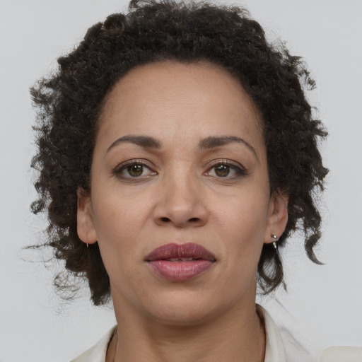 Joyful black adult female with long  brown hair and brown eyes