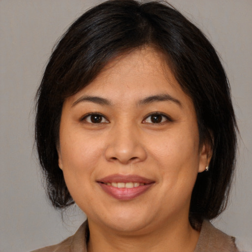 Joyful asian young-adult female with medium  brown hair and brown eyes