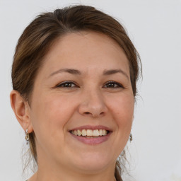 Joyful white adult female with medium  brown hair and brown eyes