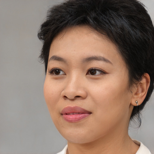 Joyful asian young-adult female with medium  brown hair and brown eyes