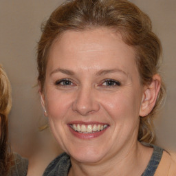 Joyful white adult female with medium  brown hair and blue eyes