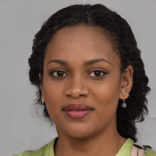 Joyful black young-adult female with medium  black hair and brown eyes