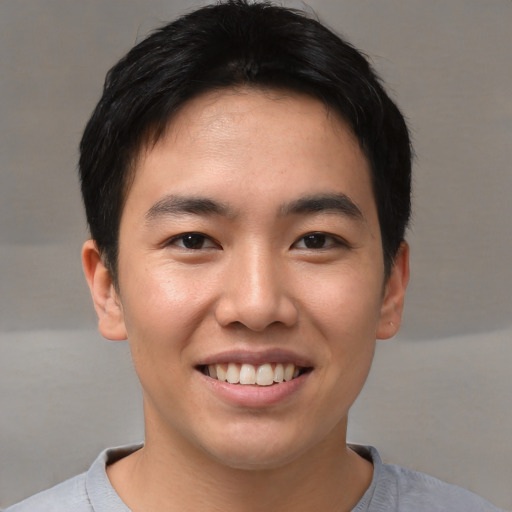 Joyful asian young-adult male with short  brown hair and brown eyes