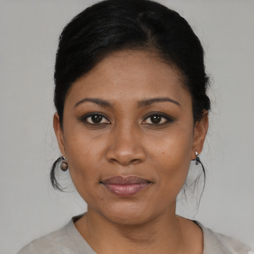 Joyful black young-adult female with short  black hair and brown eyes