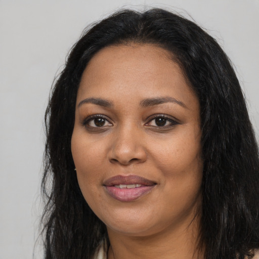 Joyful black young-adult female with long  black hair and brown eyes