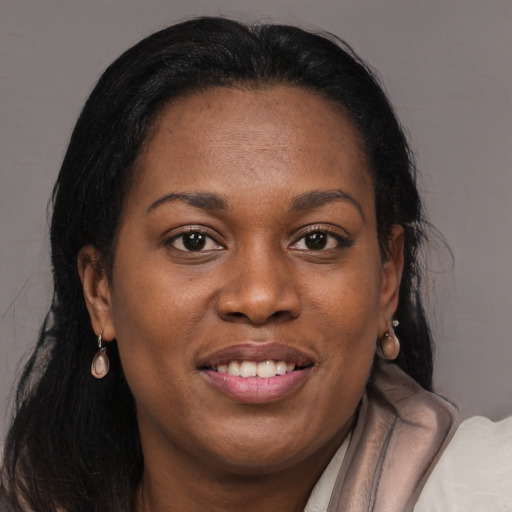 Joyful black young-adult female with long  brown hair and brown eyes