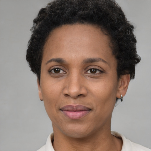 Joyful black adult female with short  black hair and brown eyes