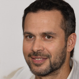 Joyful white adult male with short  brown hair and brown eyes