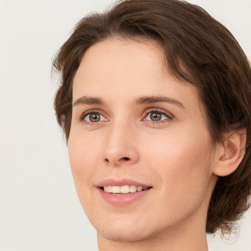 Joyful white young-adult female with medium  brown hair and green eyes