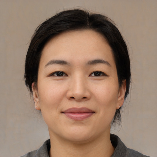 Joyful asian young-adult female with medium  brown hair and brown eyes