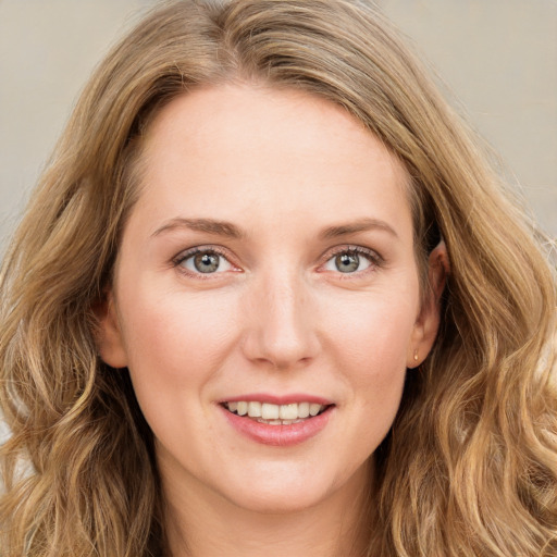 Joyful white young-adult female with long  brown hair and green eyes