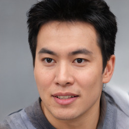 Joyful asian young-adult male with short  brown hair and brown eyes