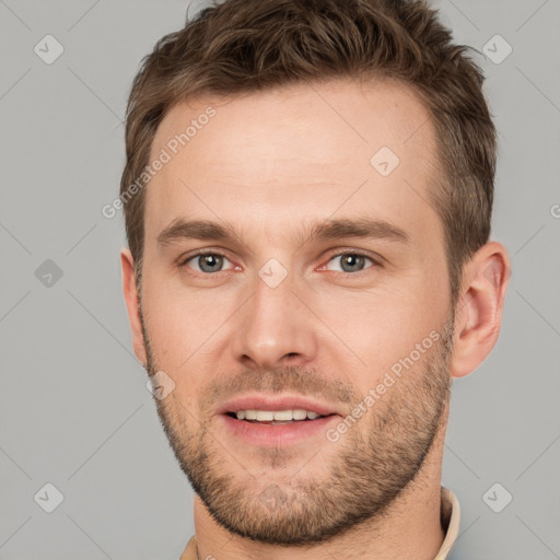 Joyful white young-adult male with short  brown hair and grey eyes