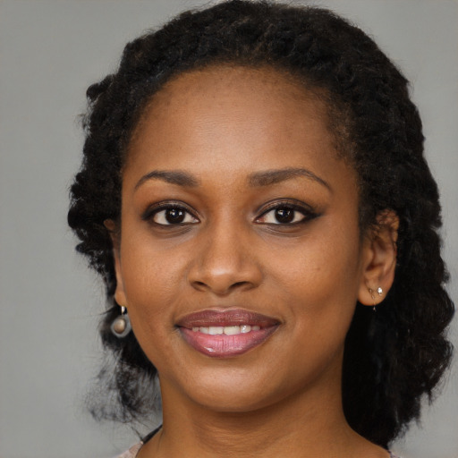 Joyful black young-adult female with long  black hair and brown eyes