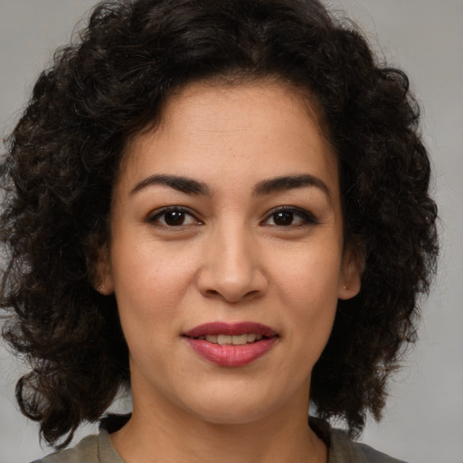 Joyful latino young-adult female with medium  brown hair and brown eyes
