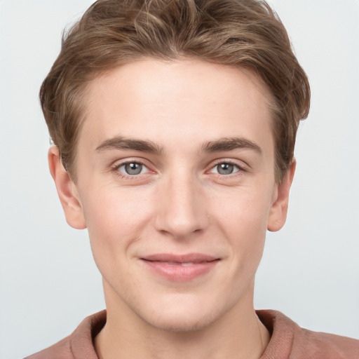 Joyful white young-adult male with short  brown hair and grey eyes