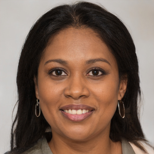 Joyful black adult female with medium  brown hair and brown eyes
