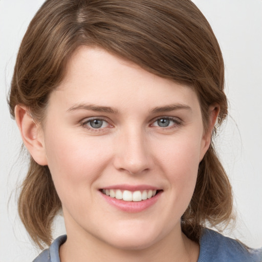 Joyful white young-adult female with medium  brown hair and blue eyes