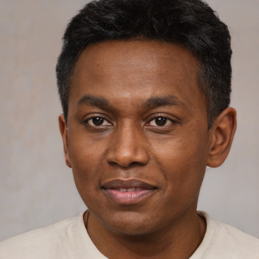 Joyful black young-adult male with short  black hair and brown eyes