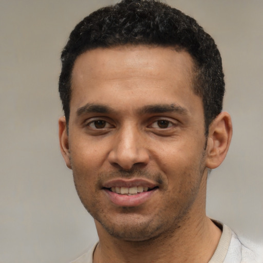 Joyful white young-adult male with short  black hair and brown eyes