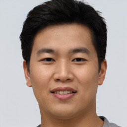 Joyful asian young-adult male with short  brown hair and brown eyes