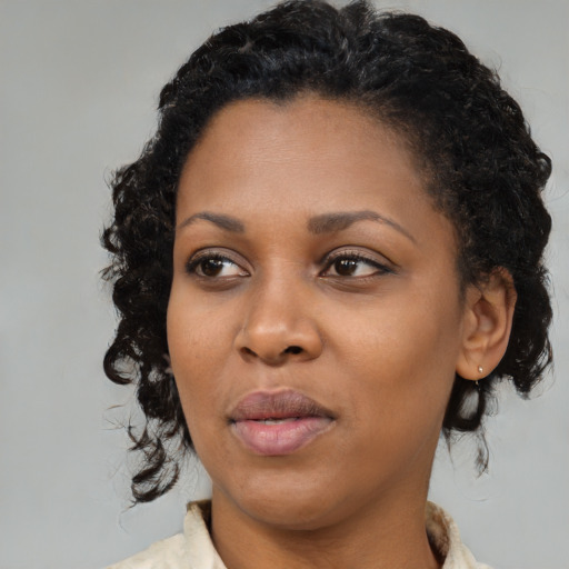 Joyful black young-adult female with medium  black hair and brown eyes