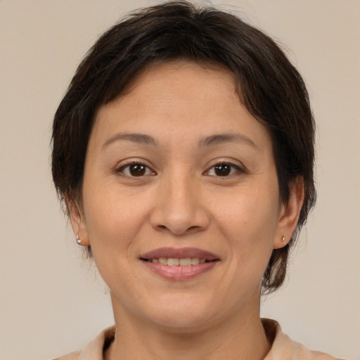 Joyful asian adult female with medium  brown hair and brown eyes