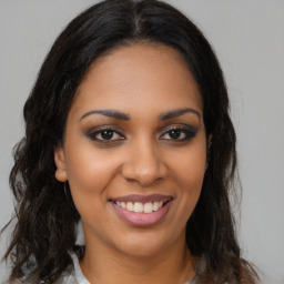 Joyful black young-adult female with long  brown hair and brown eyes