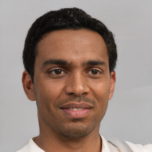 Joyful black young-adult male with short  black hair and brown eyes