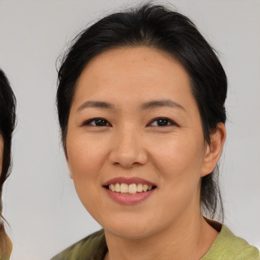 Joyful asian young-adult female with medium  brown hair and brown eyes