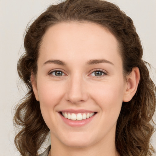 Joyful white young-adult female with long  brown hair and green eyes