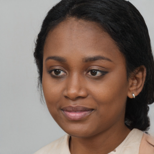 Joyful black young-adult female with medium  black hair and brown eyes