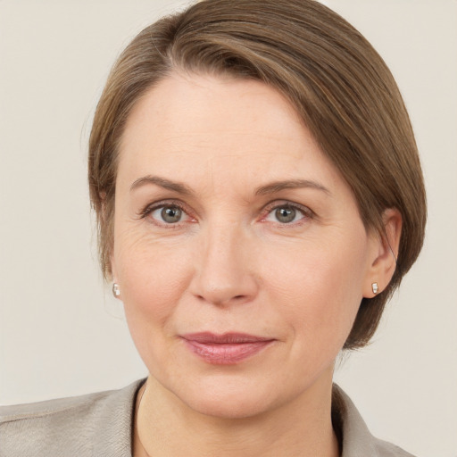 Joyful white adult female with medium  brown hair and grey eyes