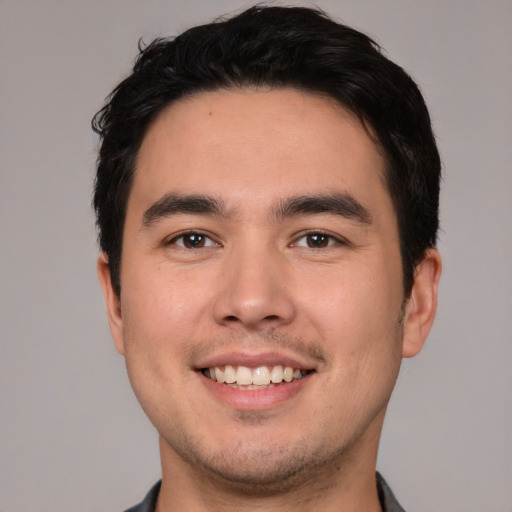 Joyful white young-adult male with short  black hair and brown eyes