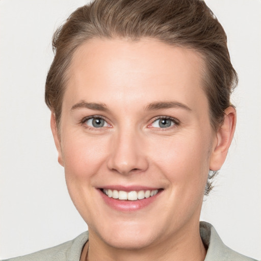 Joyful white young-adult female with short  brown hair and grey eyes