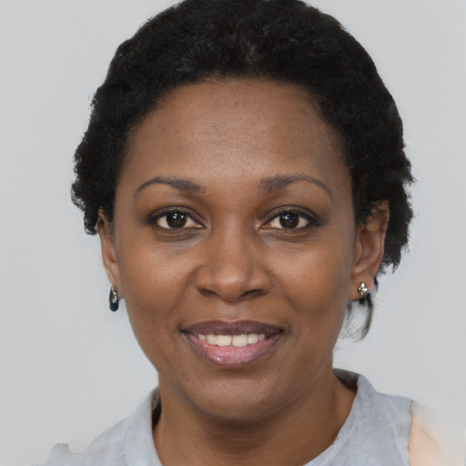 Joyful black adult female with short  black hair and brown eyes