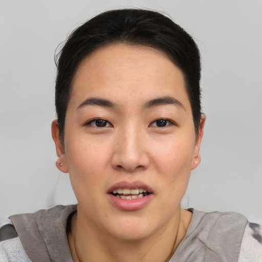 Joyful asian young-adult female with short  brown hair and brown eyes