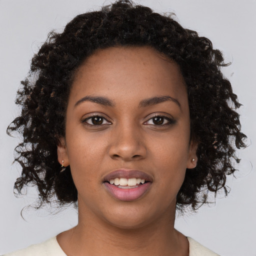 Joyful black young-adult female with short  black hair and brown eyes