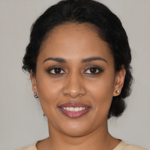 Joyful black young-adult female with short  black hair and brown eyes
