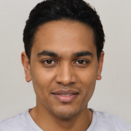 Joyful latino young-adult male with short  black hair and brown eyes