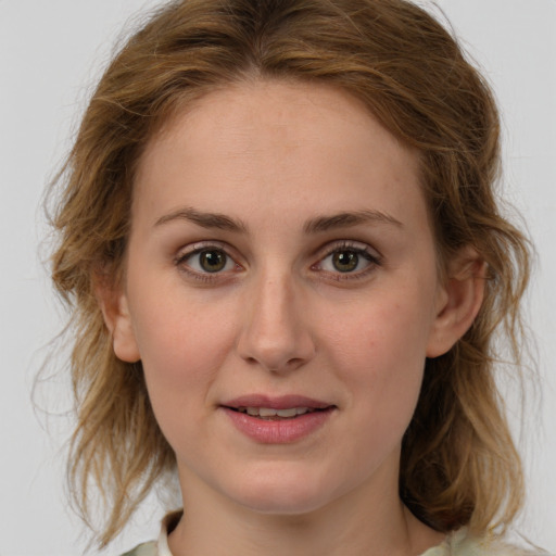 Joyful white young-adult female with medium  brown hair and green eyes