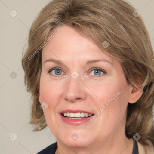 Joyful white adult female with medium  brown hair and blue eyes