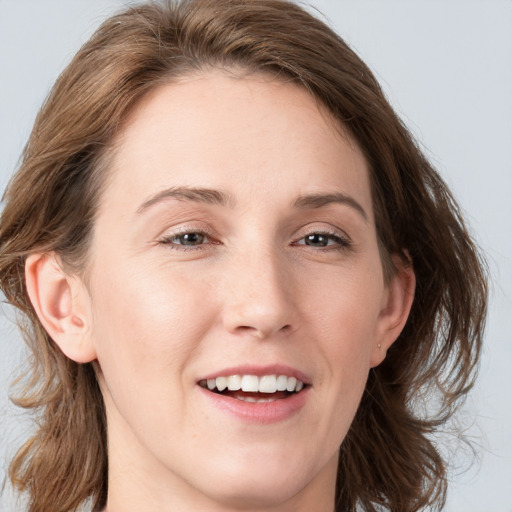 Joyful white young-adult female with medium  brown hair and blue eyes