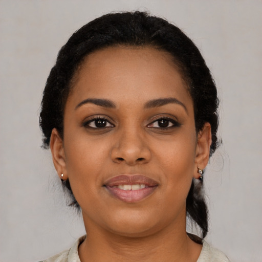 Joyful black young-adult female with short  black hair and brown eyes