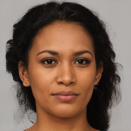 Joyful black young-adult female with long  brown hair and brown eyes