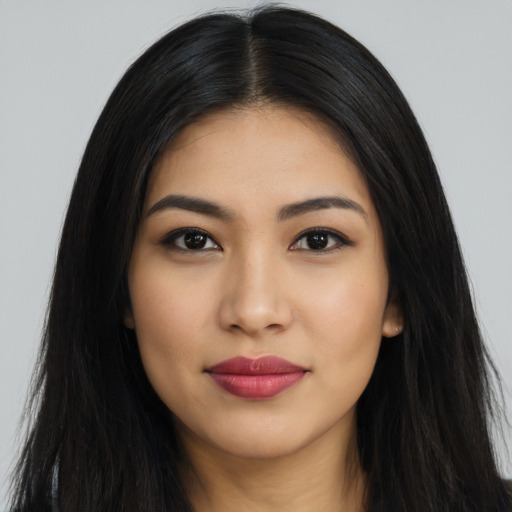 Joyful latino young-adult female with long  black hair and brown eyes
